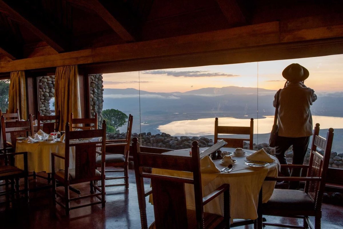 A lodge dining room with a view down into a wide crater at dusk